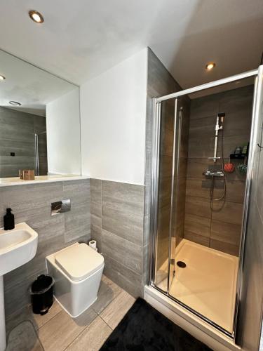 a bathroom with a shower and a toilet and a sink at Stylish Apartment City Centre in Sheffield