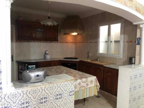 a kitchen with a table with a television on it at Villa Neji, Havre de pierre à 10 min de la plage. in Korba