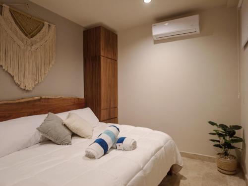 a bedroom with a white bed with two pillows at Akua Tulum Mexico in Tulum