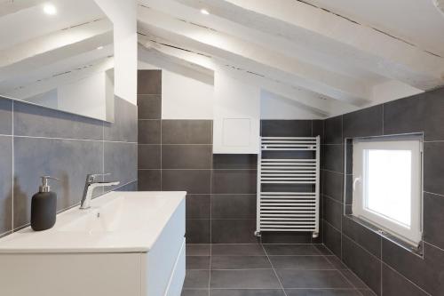 a bathroom with a white sink and a window at La casa di Po' in Trieste