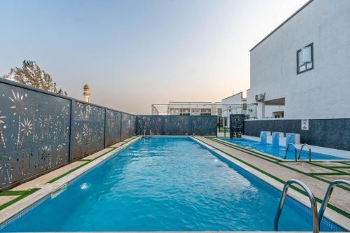 a swimming pool with blue water in front of a building at Emray Shortlets apartment in Lekki