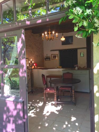 une terrasse avec une table, des chaises et une télévision dans l'établissement Château de Busqueilles - La Couple, à Autoire