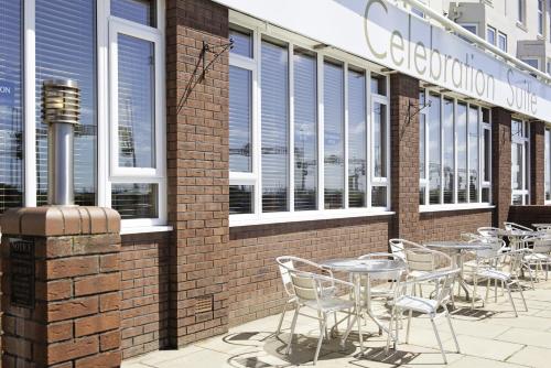 a row of tables and chairs on the side of a building at Carousel Hotel in Blackpool
