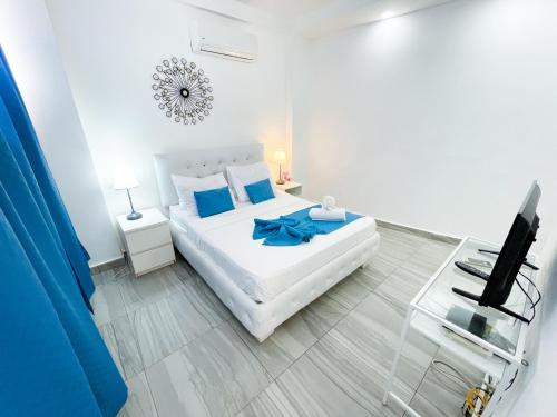 sypialnia z białym łóżkiem z niebieską kokardą w obiekcie DUCASSI Suites ROOMS & BEACH - playa Bavaro - WiFi - Parking - ROOFTOP POOL & SPA  w Punta Cana