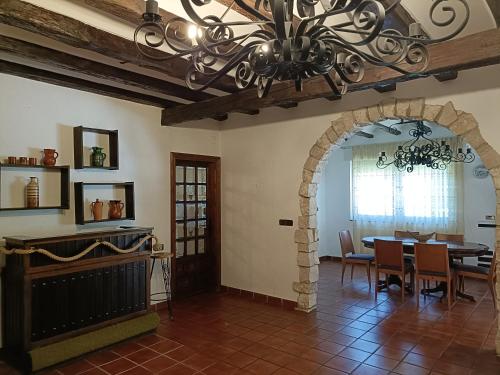 uma sala de jantar com uma mesa e um lustre em Finca Paraíso Rural em El Burgo de Osma