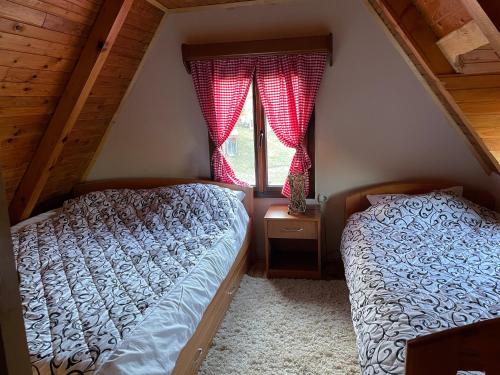 a bedroom with two beds and a window at Kuća za odmor Mališevac in Gornja Koprivna