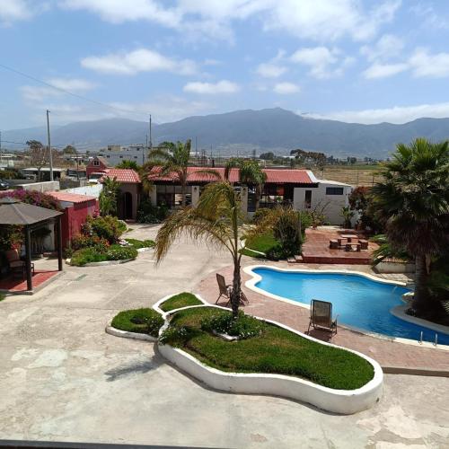 um resort com uma piscina e uma palmeira em Quinta La Toscana em Ensenada