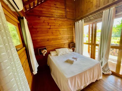 a bedroom with a bed in a wooden cabin at La Belle de Jour in Majorlândia