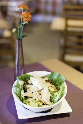 a salad in a white bowl on a table with a vase at Carousel Hotel in Blackpool