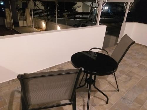 a black chair sitting next to a white wall at Skala Central House in Skala