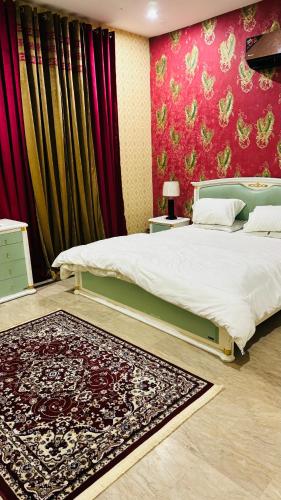 een slaapkamer met een bed en een rode muur bij Luxury Farmhouse for Stay and Events in Lahore