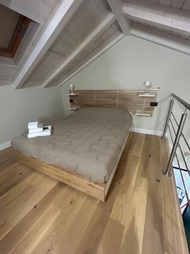 a large bed in a room with wooden floors at Elisabetta1 Guesthouse Sassari in Sassari