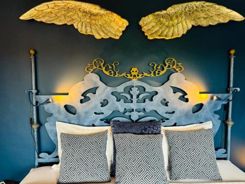 um quarto com uma cama com uma cabeceira azul e dourada em Palm View Guesthouse, adults only na Praia da Luz