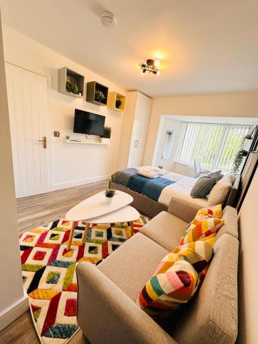 a living room with a couch and a bed at Newly Renovated Private self contained room with Private dedicated Bathroom - Selly Oak Birmingham R2 in Birmingham