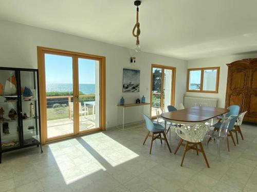 une salle à manger avec une table et des chaises et l'océan dans l'établissement 