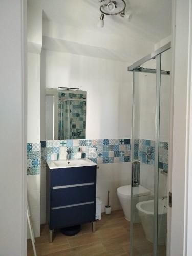 a bathroom with a sink and a toilet and a shower at Mondello Sea House in Palermo