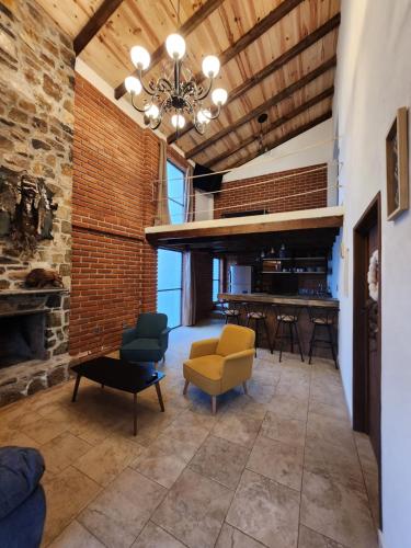 a living room with a brick wall and a chandelier at Villa Nidawi by Natut Huasca in Huasca de Ocampo