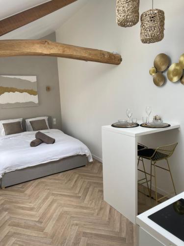 une chambre blanche avec un lit et une table dans l'établissement L’Harmonie - suite balneo, à Gournay-en-Bray