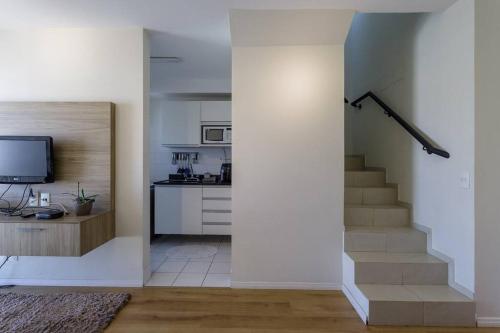 uma sala de estar com uma escada e uma cozinha em Apt⁰ aconchegante. Condomínio Menara em São Paulo
