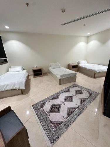 a room with two beds and a rug on the floor at شقة 3 غرف وصالتين in Riyadh
