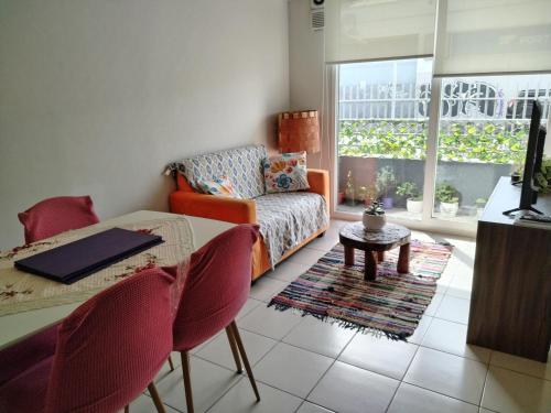 ein Wohnzimmer mit einem Sofa und einem Tisch in der Unterkunft Acogedor departamento en Temuco in Temuco