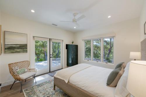 a bedroom with a bed and a chair and windows at Rancho Robles by AvantStay Vineyard Villa w Views Pool Privacy in Paso Robles