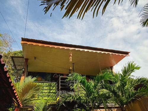 a yellow building with palm trees in front of it at Arrecife in Puerto Viejo