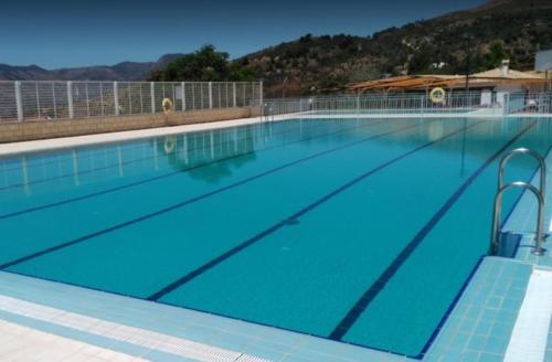 a large swimming pool with blue water at Casa rural Los Rosales in Lanjarón