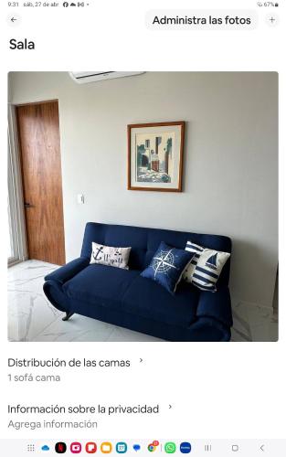 a blue couch with pillows in a living room at Sol y mar in Boca del Río