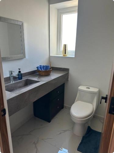 a bathroom with a sink and a toilet and a mirror at Sol y mar in Boca del Río