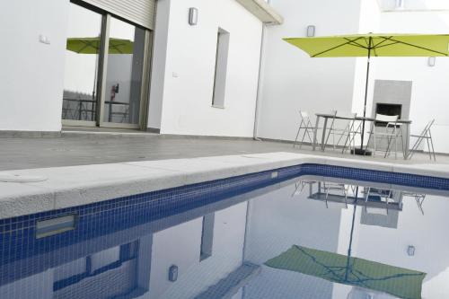 uma piscina com uma mesa e um guarda-sol em Apartamentos Turísticos Clavero em Almagro