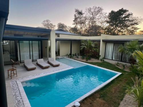 uma piscina em frente a uma casa em Casa Delirio - Beautiful and Modern em Refundores