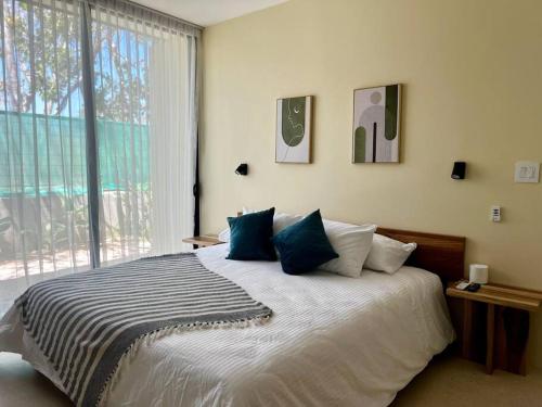 um quarto com uma cama grande e almofadas azuis em Casa Delirio - Beautiful and Modern em Refundores