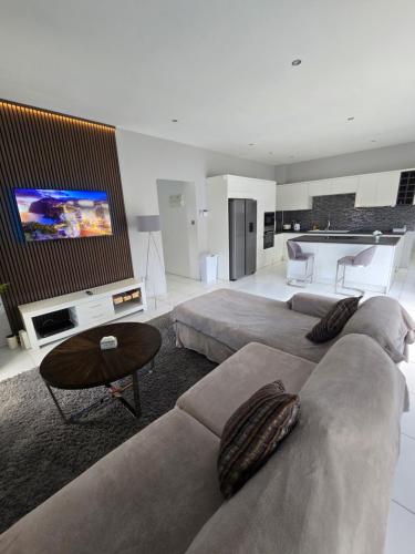 sala de estar con 2 sofás y TV de pantalla plana en Belle Luxury Apartments, en Gros Islet