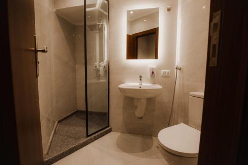 uma casa de banho com um WC, um lavatório e um chuveiro em Sama hotel no Cairo