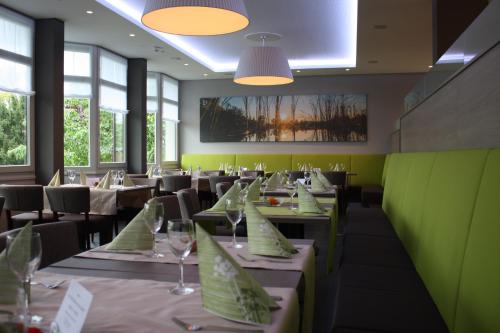 - une salle à manger avec des tables, des chaises et des fenêtres dans l'établissement Hotel am Schlossberg, à Herrenberg