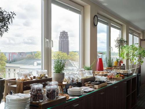 a buffet in a room with large windows at Flemings Hotel Frankfurt Main-Riverside in Frankfurt