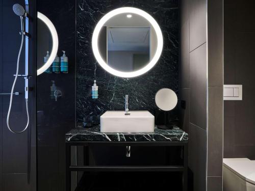 uma casa de banho com um lavatório e um espelho em Novotel Melbourne Airport em Melbourne