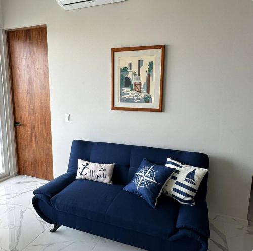 a blue couch in a living room with pillows on it at Sol y mar in Boca del Río