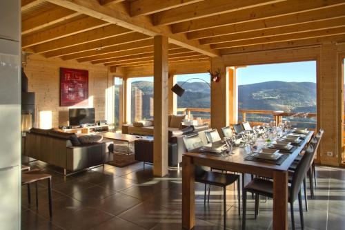 a dining room with a table and chairs and a couch at Les Chalets de La Marcairie in Metzeral