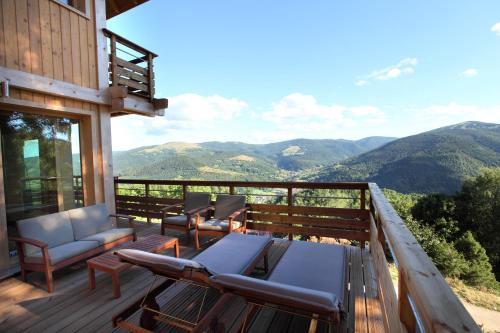 a balcony with chairs and a view of mountains at Les Chalets de La Marcairie in Metzeral