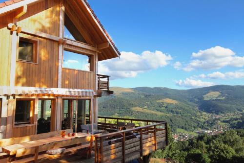 a house with a balcony with a view of the mountains at Les Chalets de La Marcairie in Metzeral