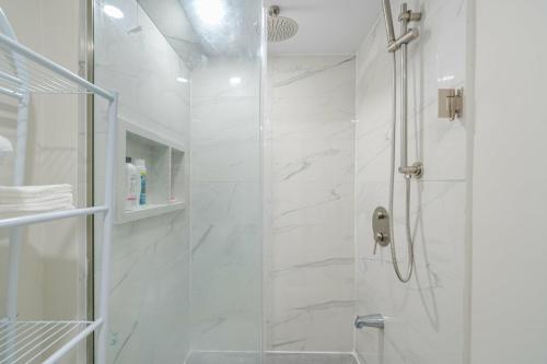 uma casa de banho branca com um chuveiro com uma porta de vidro em Private basement bedrooms in Oakville em Oakville