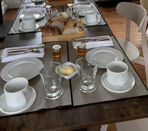 Saint-MarcoufにあるDomaine de Marculfoの白い皿とカップが置かれたテーブルとテーブルが置かれたテーブル