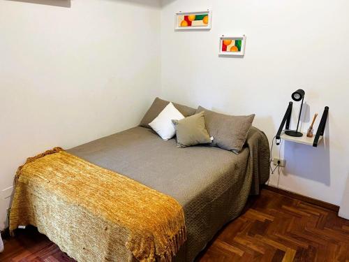 een slaapkamer met een bed met een gele deken erop bij Departamento Céntrico Tucumán 1B in San Miguel de Tucumán