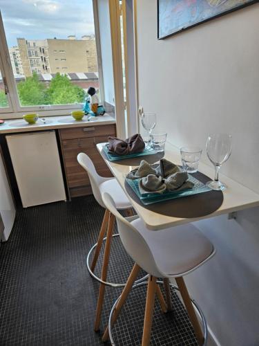 une cuisine avec une table et deux chaises ainsi qu'une fenêtre dans l'établissement HOME PARIS TOUR EIFFEL, à Paris