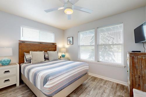 a bedroom with a bed and a ceiling fan at Lazy Lookout on Devils Lake in Lincoln City