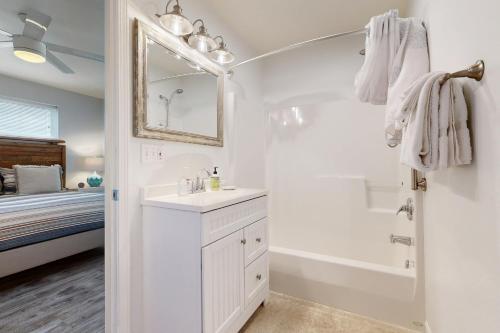 een witte badkamer met een bad, een wastafel en een douche bij Lazy Lookout on Devils Lake in Lincoln City