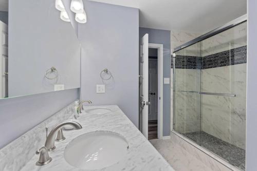 uma casa de banho branca com um lavatório e um chuveiro em Blue Dreams em Prince George