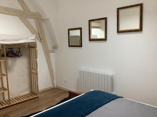 sypialnia z łóżkiem i 3 lustrami na ścianie w obiekcie Maison cœur de Chablis w mieście Chablis